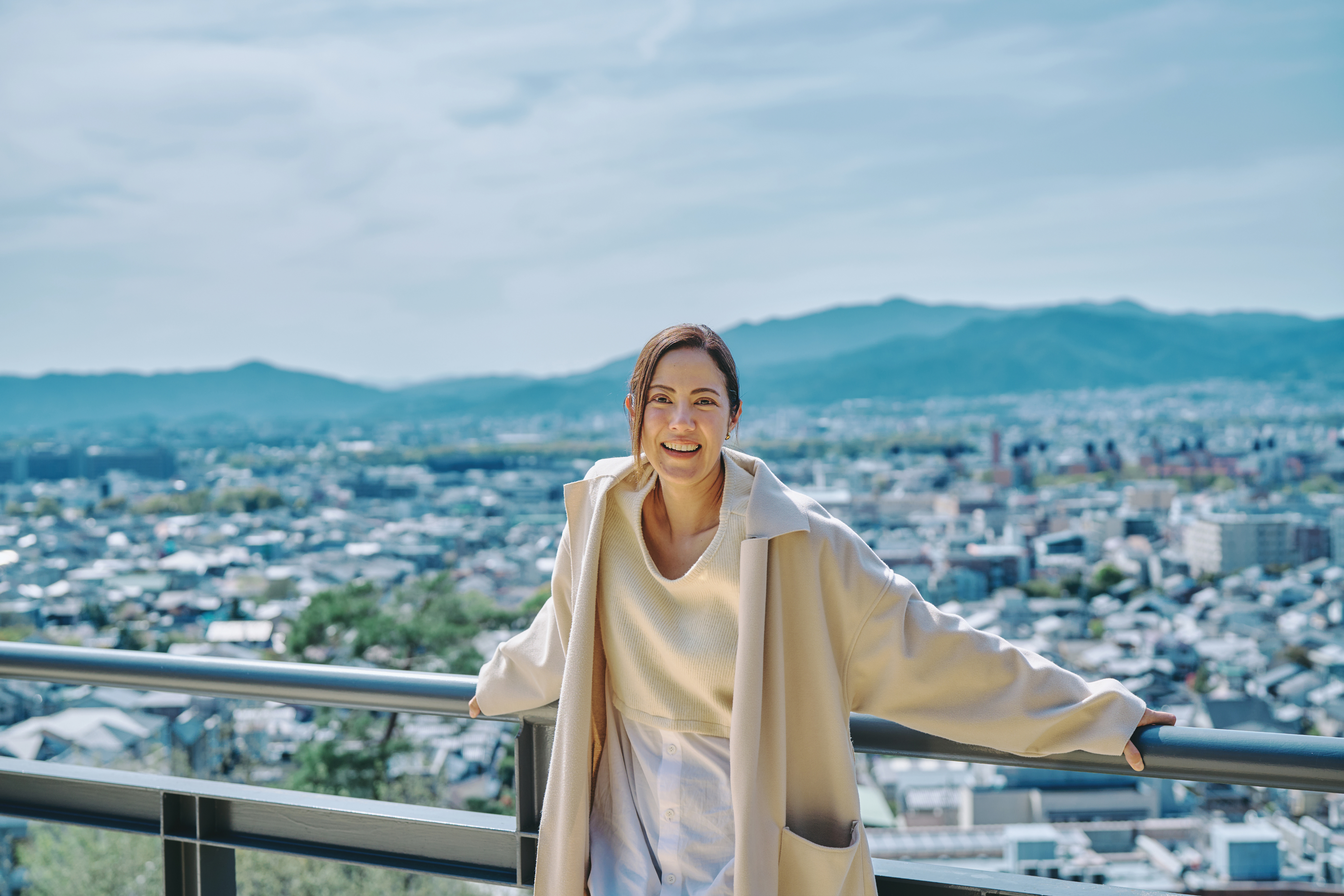Two women sitting at a modern table talking with a city view behind them.